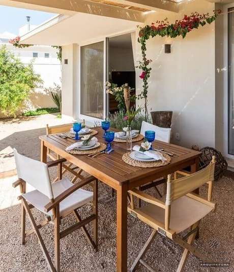 14. Área externa com mesa e cadeira de Madeira. Projeto por Jannini Sagarra Arquitetura 14. Área externa com mesa e cadeira de Madeira. Projeto por Jannini Sagarra Arquitetura