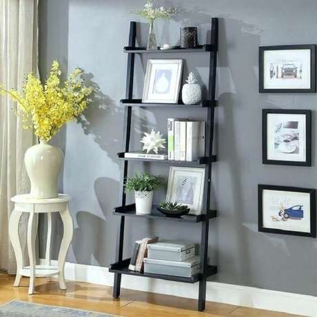 32. Estante escada preta serve de apoio para itens decorativos da sala de estar. Fonte: Pinterest 32. Estante escada preta serve de apoio para itens decorativos da sala de estar. Fonte: Pinterest