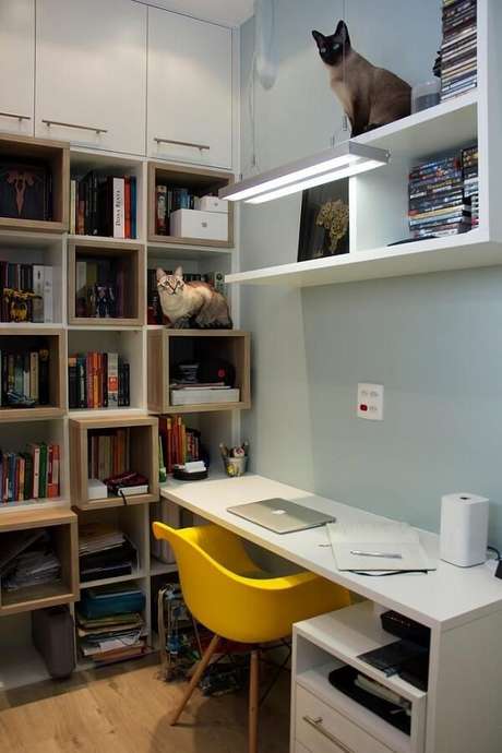 13. Área de estudos conta com mesa branca e cadeira eames amarela. Projeto por Ana Lúcia Adriano 13. Área de estudos conta com mesa branca e cadeira eames amarela. Projeto por Ana Lúcia Adriano