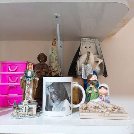 Objetos temáticos estão espalhados pela casa de Milena, que diz ter escapado da morte após intercessão da freira Objetos temáticos estão espalhados pela casa de Milena, que diz ter escapado da morte após intercessão da freira