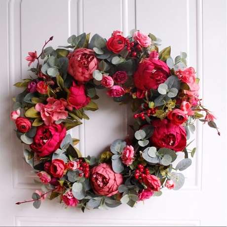 49. Enfeite de natal para porta feito com flores artificiais. Fonte: Pinterest