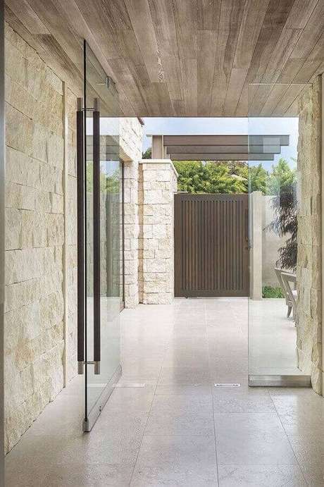 23. Parede com pedra miracema e porta de vidro para a entrada da casa. Fonte: Pinterest 23. Parede com pedra miracema e porta de vidro para a entrada da casa. Fonte: Pinterest