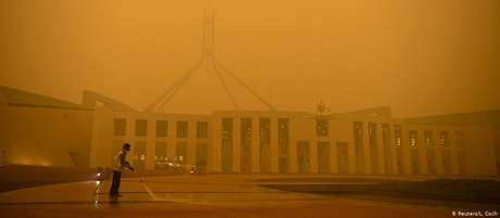 Faxineiro limpa pátio do Parlamento em Camberra: ar da capital australiana é afetado por queimadas Faxineiro limpa pátio do Parlamento em Camberra: ar da capital australiana é afetado por queimadas