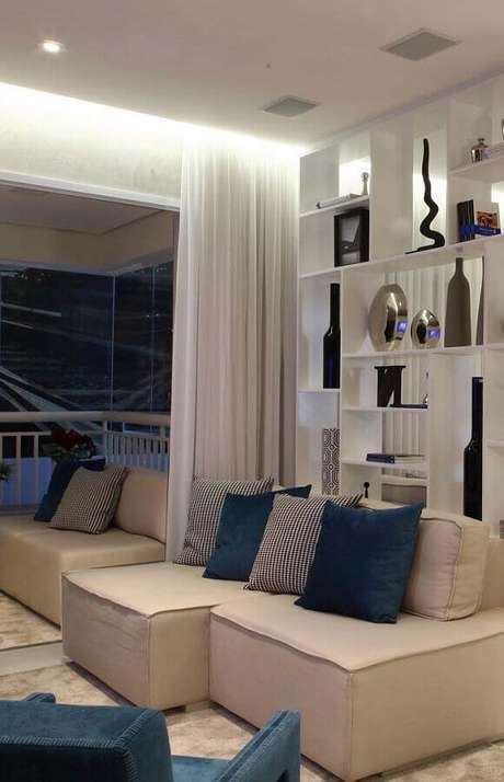 8. Decoração com sofá pequeno para sala em tons neutros com estante vazada – Foto: Pinterest 8. Decoração com sofá pequeno para sala em tons neutros com estante vazada – Foto: Pinterest