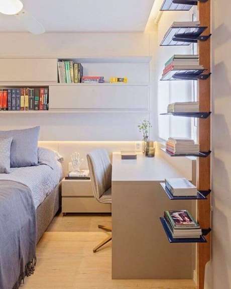 9. Decoração neutra para quarto juvenil planejado com móveis brancos e prateleiras azuis para livros – Foto: Dubal Arquitetura & Design