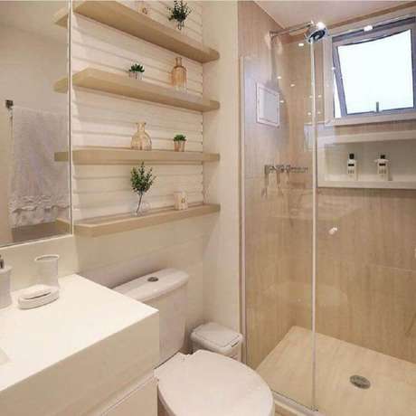 26. Decoração em tons neutros para banheiro de apartamento pequeno com prateleiras de madeira para decoração – Foto: Mônise Rosa 26. Decoração em tons neutros para banheiro de apartamento pequeno com prateleiras de madeira para decoração – Foto: Mônise Rosa