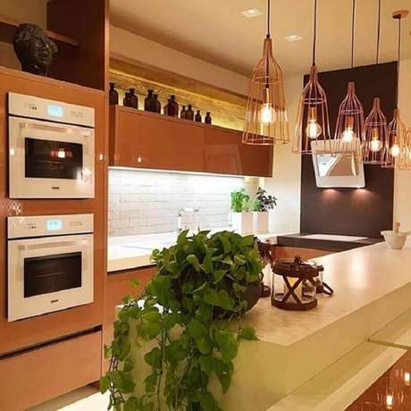 34. Pendente aramado cobre para decoração de cozinha planejada marrom com bancada bege – Foto: Romero Duarte & Arquitetos 34. Pendente aramado cobre para decoração de cozinha planejada marrom com bancada bege – Foto: Romero Duarte & Arquitetos