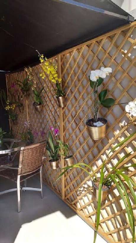 20. Área externa decorada com treliça de madeira na parede com vasos de plantas – Foto: Elo7 20. Área externa decorada com treliça de madeira na parede com vasos de plantas – Foto: Elo7