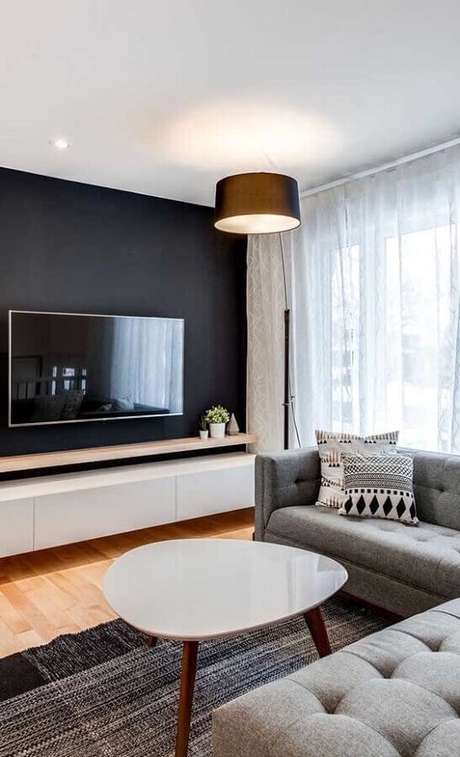 62. Parede na cor preta para decoração de sala de estar com sofá cinza e piso de madeira – Foto: Ideias Decor 62. Parede na cor preta para decoração de sala de estar com sofá cinza e piso de madeira – Foto: Ideias Decor