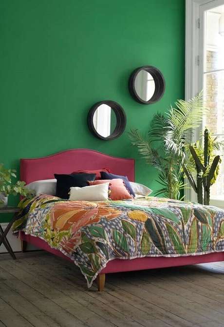 39. Parede verde para decoração de quarto de casal com cama rosa e espelhos redondos – Foto: Otimizi