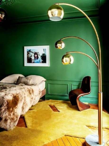 53. Parede verde para quarto decorado com luminária dourada – Foto: Apartment Therapy