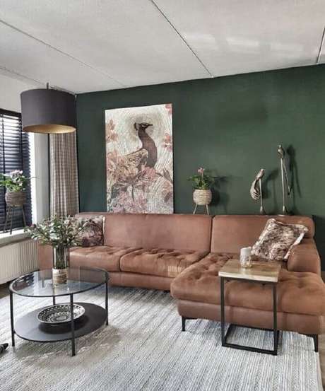 58. Parede verde escura para decoração de sala de estar com sofá marrom – Foto: Assetproject