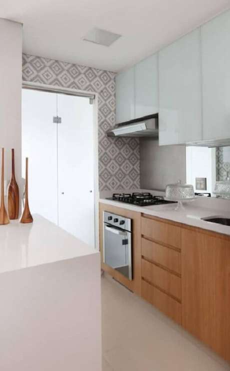 36. Decoração simples para cozinha planejada com cooktop e armários de madeira – Foto: Arquitrecos 36. Decoração simples para cozinha planejada com cooktop e armários de madeira – Foto: Arquitrecos