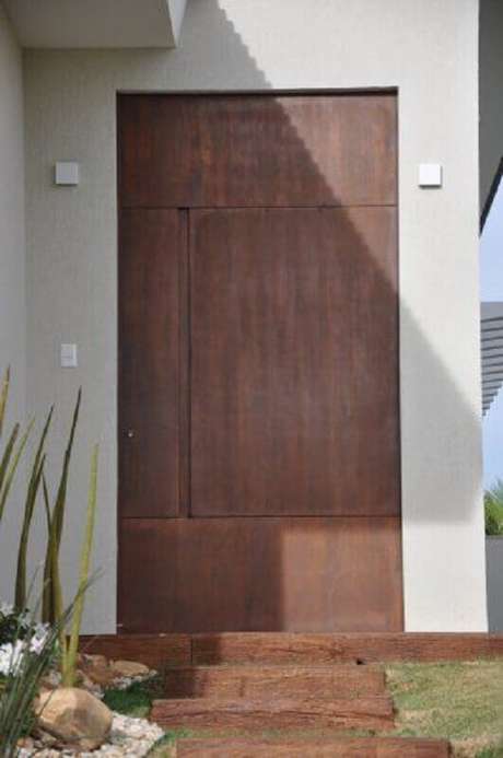 8. A porta de ferro pode dar um ar arrojado à fachada da casa – Foto: Univence Construtora 8. A porta de ferro pode dar um ar arrojado à fachada da casa – Foto: Univence Construtora