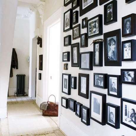 7. Casa com parede decorada com painel de fotos com molduras pretas 7. Casa com parede decorada com painel de fotos com molduras pretas