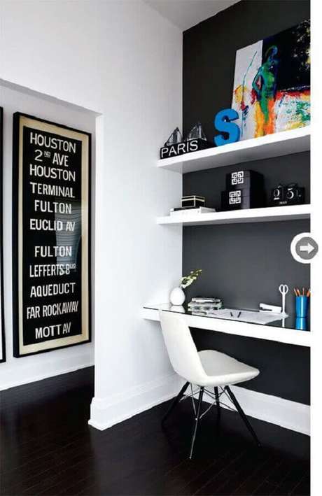 58. Home office decorado com parede preta e prateleiras e bancada branca – Foto: Achados de Decoração 58. Home office decorado com parede preta e prateleiras e bancada branca – Foto: Achados de Decoração