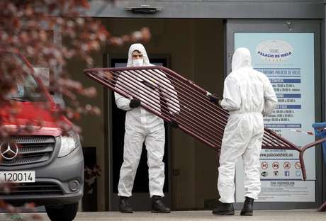 Homens trabalham para isolar a região de Madri, na Espanha