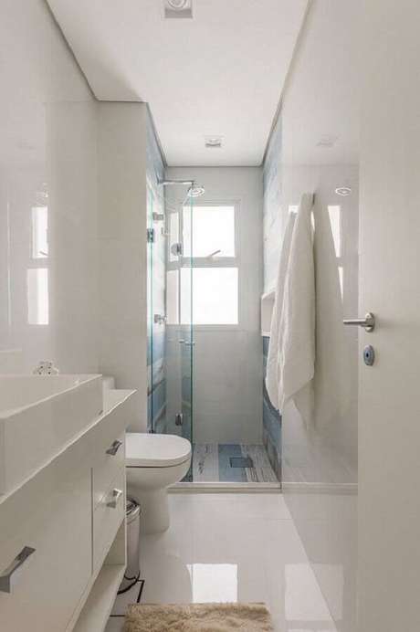 18. O banheiro branco ganha o detalhe do revestimento azul ao fundo no banheiro decorado – Foto: Idealizzare Arquitetura 18. O banheiro branco ganha o detalhe do revestimento azul ao fundo no banheiro decorado – Foto: Idealizzare Arquitetura