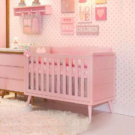 47. Quarto de bebê rosa decorado com papel de parede de bolinhas e vários quadrinhos – Foto: Pinterest 47. Quarto de bebê rosa decorado com papel de parede de bolinhas e vários quadrinhos – Foto: Pinterest