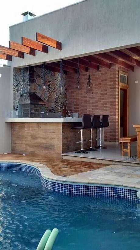 28. Área gourmet simples com churrasqueira de vidro e piscina – Foto: Larissa Carbone Arquitetura