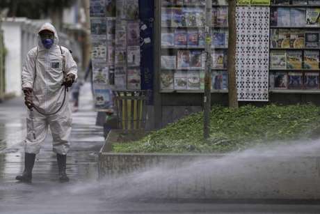 Funcionários realizam limpeza e desinfecção de calçada e mobiliário urbano em área da Avenida Paulista, região central de São Paulo