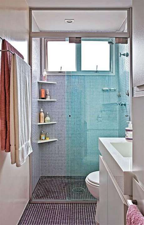 49. Decoração simples com prateleira de canto para banheiro decorado com pastilhas azuis – Foto: Tudo Construção 49. Decoração simples com prateleira de canto para banheiro decorado com pastilhas azuis – Foto: Tudo Construção