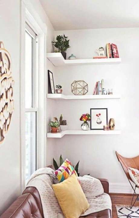 57. Prateleira de canto para sala branca decorada com sofá de couro marrom – Foto: Futurist Architecture 57. Prateleira de canto para sala branca decorada com sofá de couro marrom – Foto: Futurist Architecture