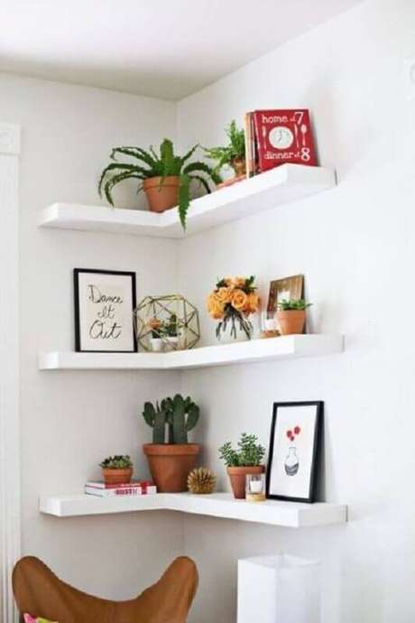 63. Vasos de plantas e quadros para decoração de prateleira de canto branca – Foto: Apartment Therapy 63. Vasos de plantas e quadros para decoração de prateleira de canto branca – Foto: Apartment Therapy