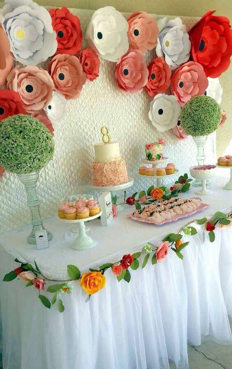 29. As flores na borda da mesa complementam a decoração de forma delicada. 29. As flores na borda da mesa complementam a decoração de forma delicada.