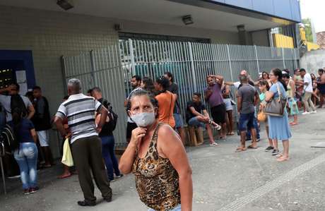 Pessoas esperam em fila em frente a agência da Caixa para receber auxílio emergencial durante o surto do Covid-19 15/04/2020 REUTERS/Ricardo Moraes