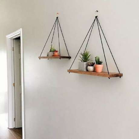 27. Modelo de prateleira suspensa de madeira para decoração minimalista – Foto: Viajando no Apê 27. Modelo de prateleira suspensa de madeira para decoração minimalista – Foto: Viajando no Apê