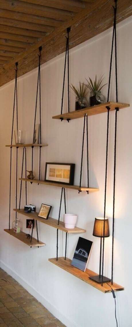 33. Parede decorada com prateleira de madeira suspensa por corda – Foto: Pinterest 33. Parede decorada com prateleira de madeira suspensa por corda – Foto: Pinterest