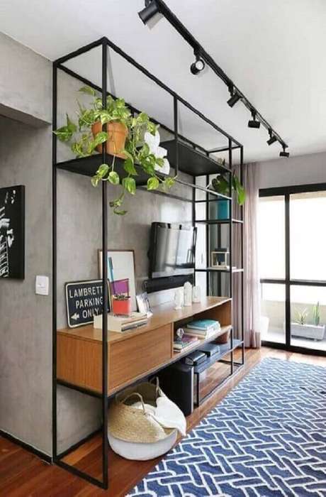 51. Estante industrial com nicho de madeira para decoração de sala com tapete azul e parede de cimento queimado – Foto: Pinterest 51. Estante industrial com nicho de madeira para decoração de sala com tapete azul e parede de cimento queimado – Foto: Pinterest