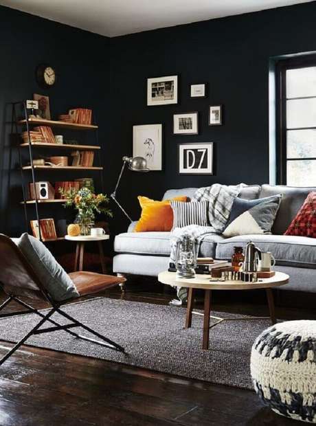 36. Sala com parede preta decorada com sofá cinza e almofadas coloridas – Foto: Homedit