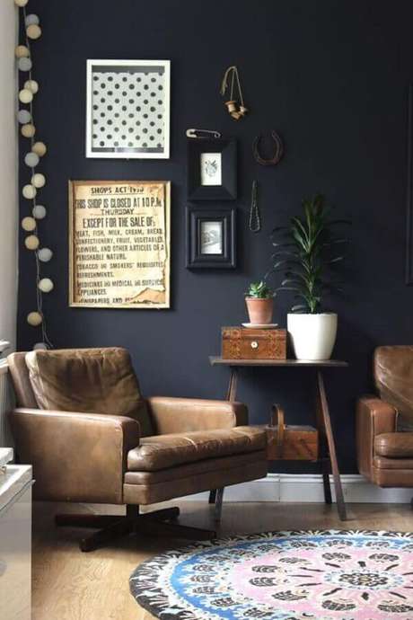 37. Sala preta decorada com mesa lateral de madeira e poltrona de couro – Foto: Pinterest