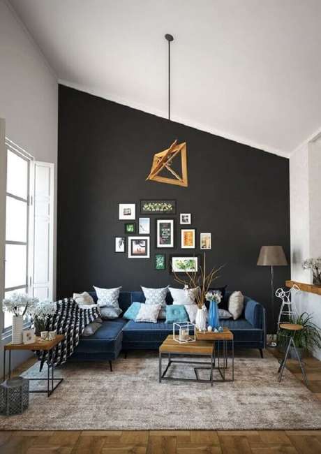38. Decoração com sofá de canto azul para sala com parede preta ampla – Foto: Behance