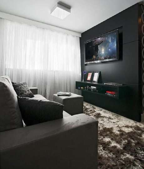 40. Sala preta decorada com sofá cinza e tapete felpudo marrom – Foto: Pinterest