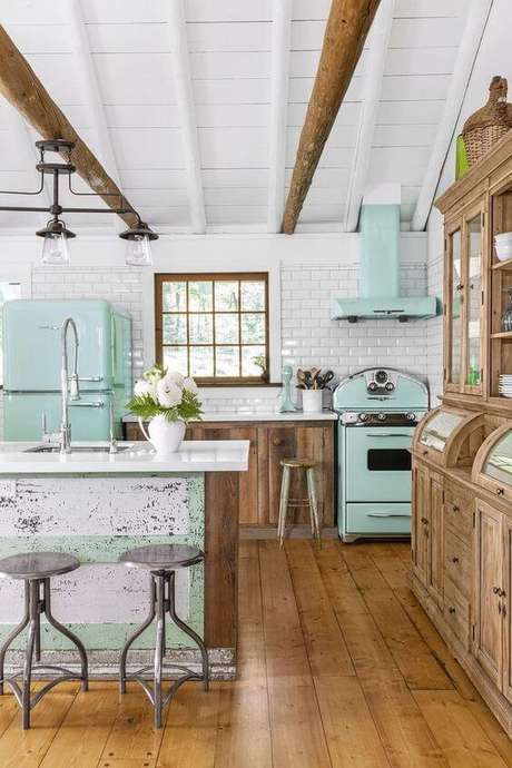 17. Cozinha com fogão retrô azul claro e móveis de madeira bonitos – Via: Country Living