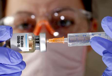 Mulher segura seringa e frasco rotulado como de vacina para Covid-19 em foto de ilustração 10/04/2020 REUTERS/Dado Ruvic