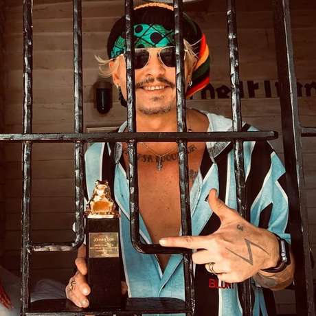 Johnny Depp debocha de sua situação com foto de troféu atrás das grades Johnny Depp debocha de sua situação com foto de troféu atrás das grades