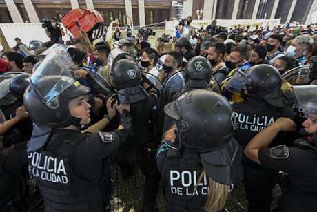 Policiais tentam dispersar os torcedores (Foto: JUAN MABROMATA / AFP) Policiais tentam dispersar os torcedores (Foto: JUAN MABROMATA / AFP)