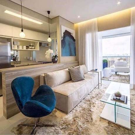 38. Sala bege pequena decorada com poltrona azul escura e tapete felpudo – Foto: Dicas de Mulher 38. Sala bege pequena decorada com poltrona azul escura e tapete felpudo – Foto: Dicas de Mulher