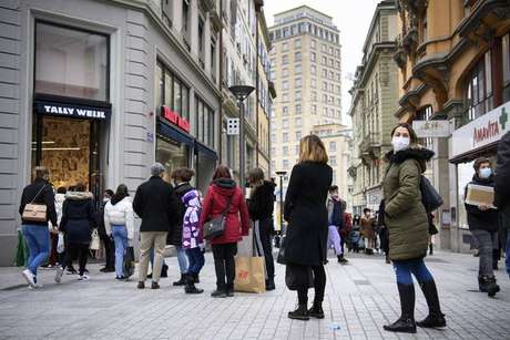 Fila em loja de Lausanne, na Suíça, antes de fechamento do comércio não essencial, que passa a valer em 18 de janeiro Fila em loja de Lausanne, na Suíça, antes de fechamento do comércio não essencial, que passa a valer em 18 de janeiro