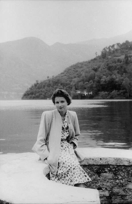 Mulher posa ao lado de lago Mulher posa ao lado de lago