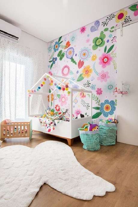 55. Decoração de quarto para criança menina com cama casinha e papel de parede floral colorido – Foto: MOOUI