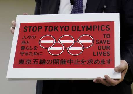 Advogado Kenji Utsunomiya exibe cartaz durante entrevista coletiva em Tóquio após envio de petição solicitando o cancelamento da Olimpíada de Tóquio, no Japão
14/05/2021 REUTERS/Naoki Ogura