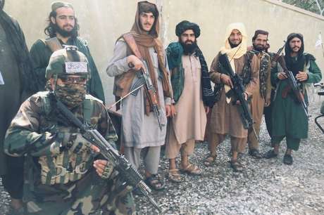 Membro das forças especiais do Talebã posa, ajoelhado, com outros integrantes do grupo