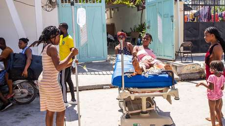 Mulher ferida é carregada em maca Mulher ferida é carregada em maca