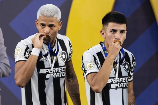 Matheus Martins (&agrave; esquerda) beija a medalha de campe&atilde;o da Libertadores