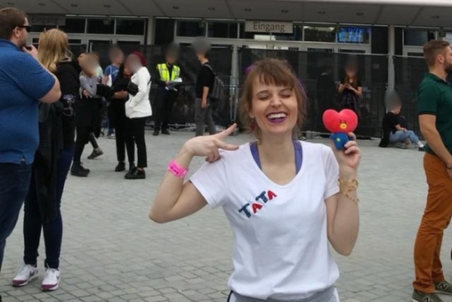 Liana posa na entrada de arena para assistir BTS em Berlim